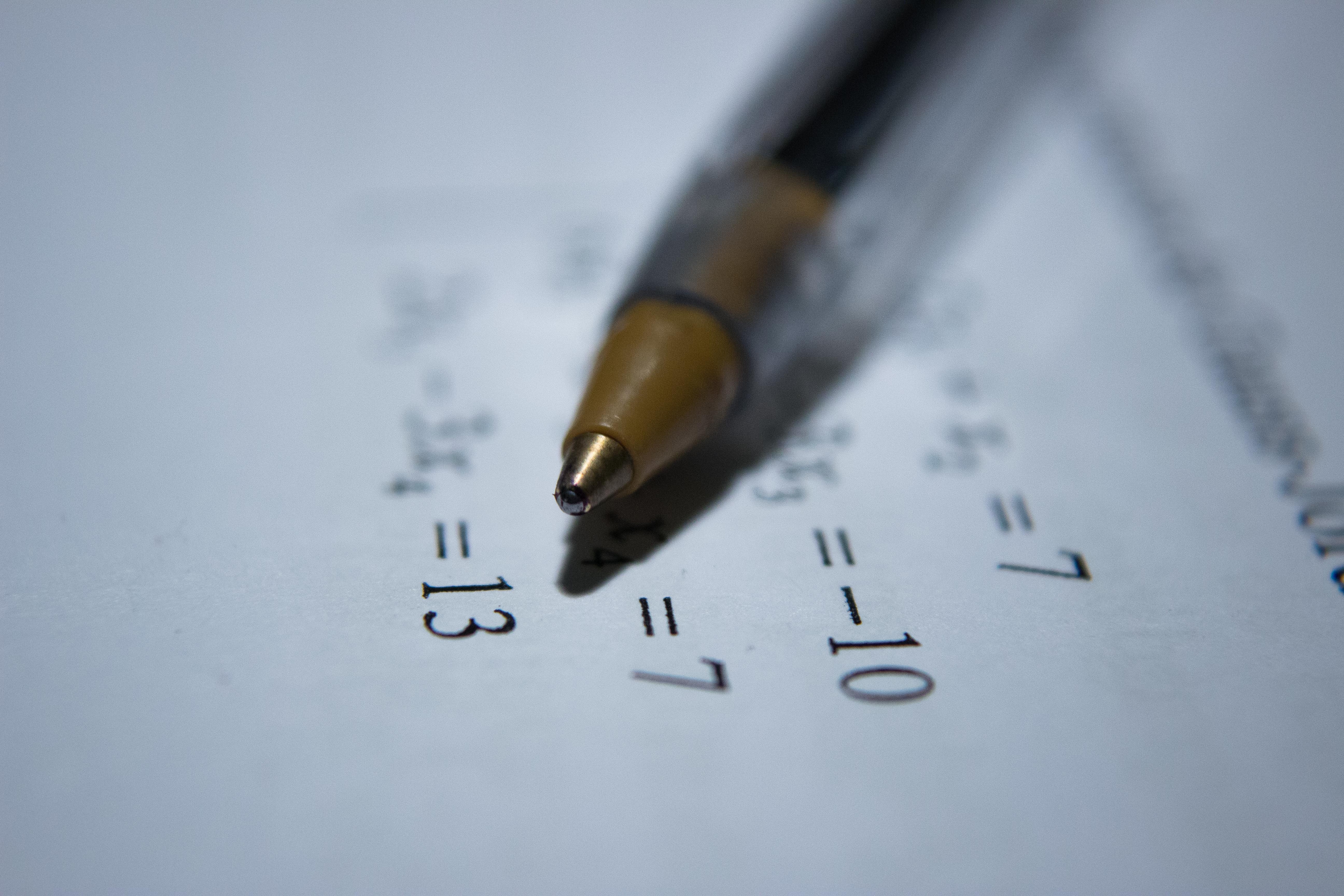 Un stylo bic posé sur une feuille avec des équations mathématique