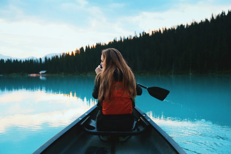 Une femme fait du kayak sur le lac Louise au Canada