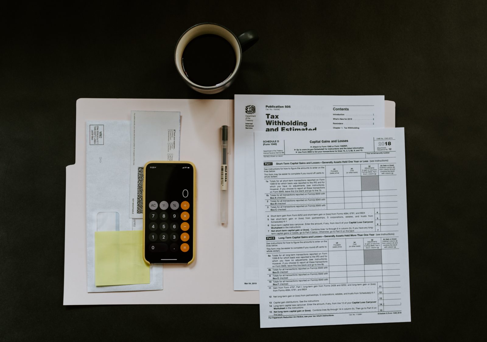Des papiers fiscaux, un café et calculette sur un bureau